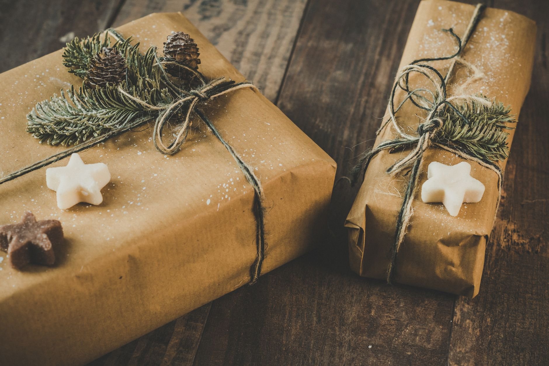 Eco-friendly gifts wrapped in brown kraft paper with natural pine decorations on a wooden table — representing Songcraft's gift-ready packaging