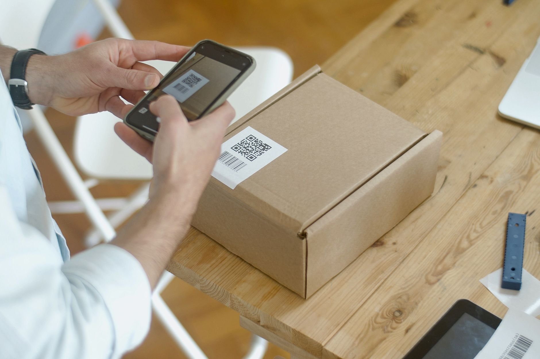 Person scanning a QR code on a handcrafted package with a smartphone
